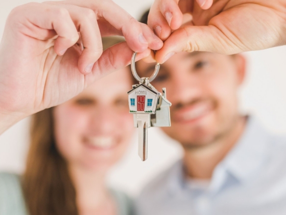 House keys held in front of a smiling couple