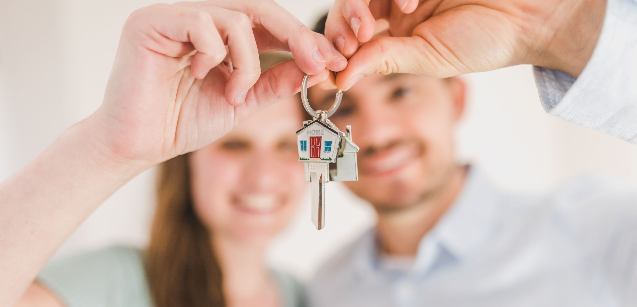 House keys held in front of a smiling couple