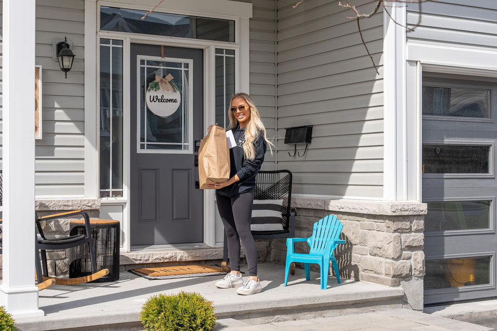 The West Team member collecting a food donation bag from a Bridlewood home