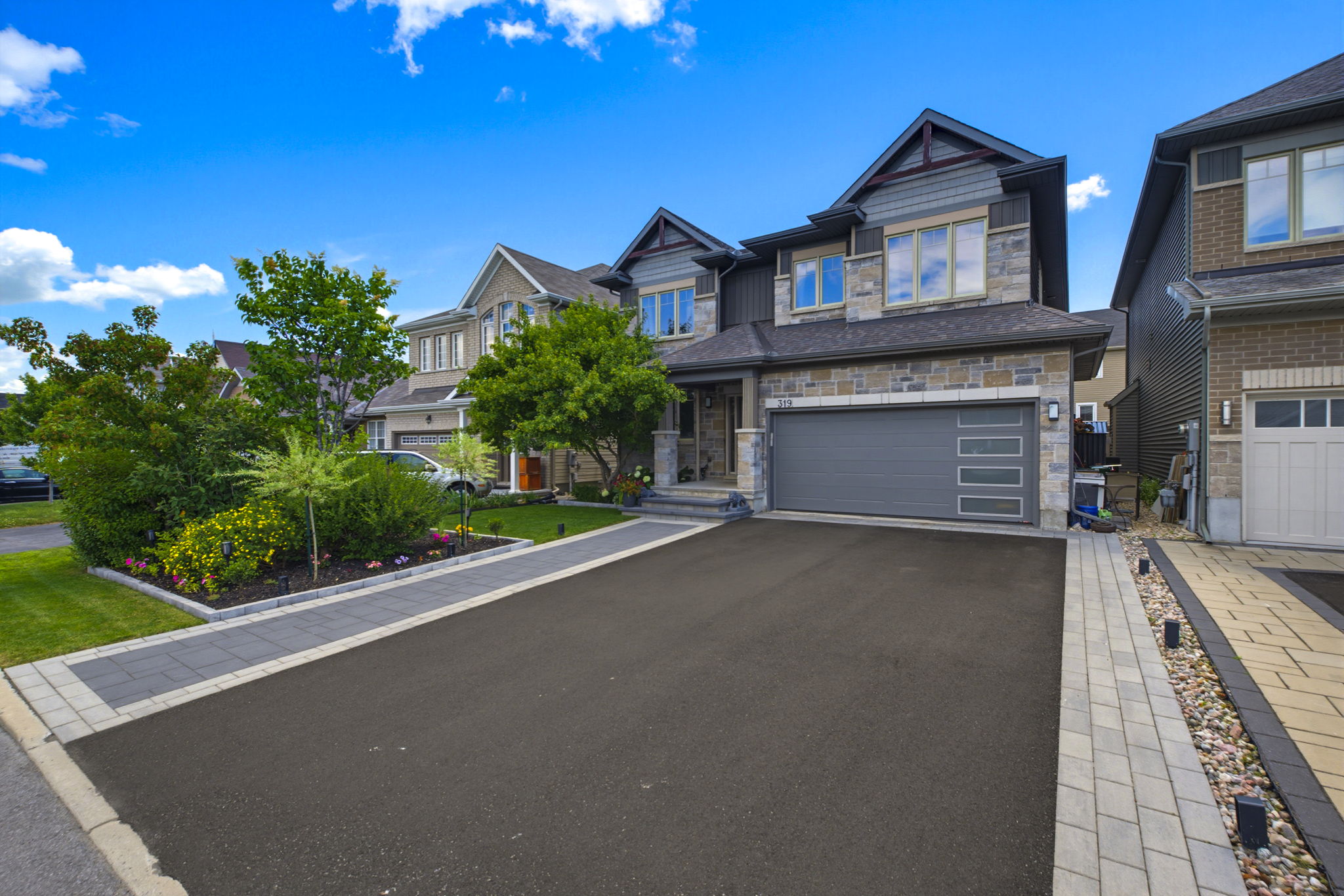 Ottawa home with tidy landscaping, a paved driveway and a well-maintained entrance